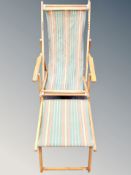 A folding vintage wooden deck chair with foot rest