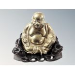 A Chinese cast brass figure of a seated Buddha on carved wooden base, overall height 14 cm.