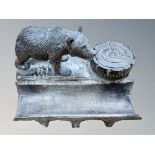A Black Forest desk stand with inkwell and pen tray, surmounted by a bear, width 17cm.
