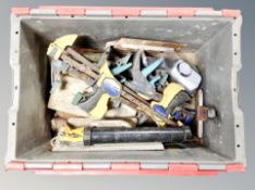 A plastic crate of assorted tools and hardware, drill bits, planers etc.