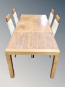A contemporary extending dining table with leaf and a set of four wood and leather high back dining
