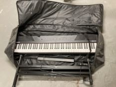 An Alesis electric keyboard with stand and carry bag