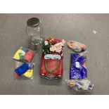 A glass lidded dispenser together with a Santa Claus ornament and a quantity of juggling items.