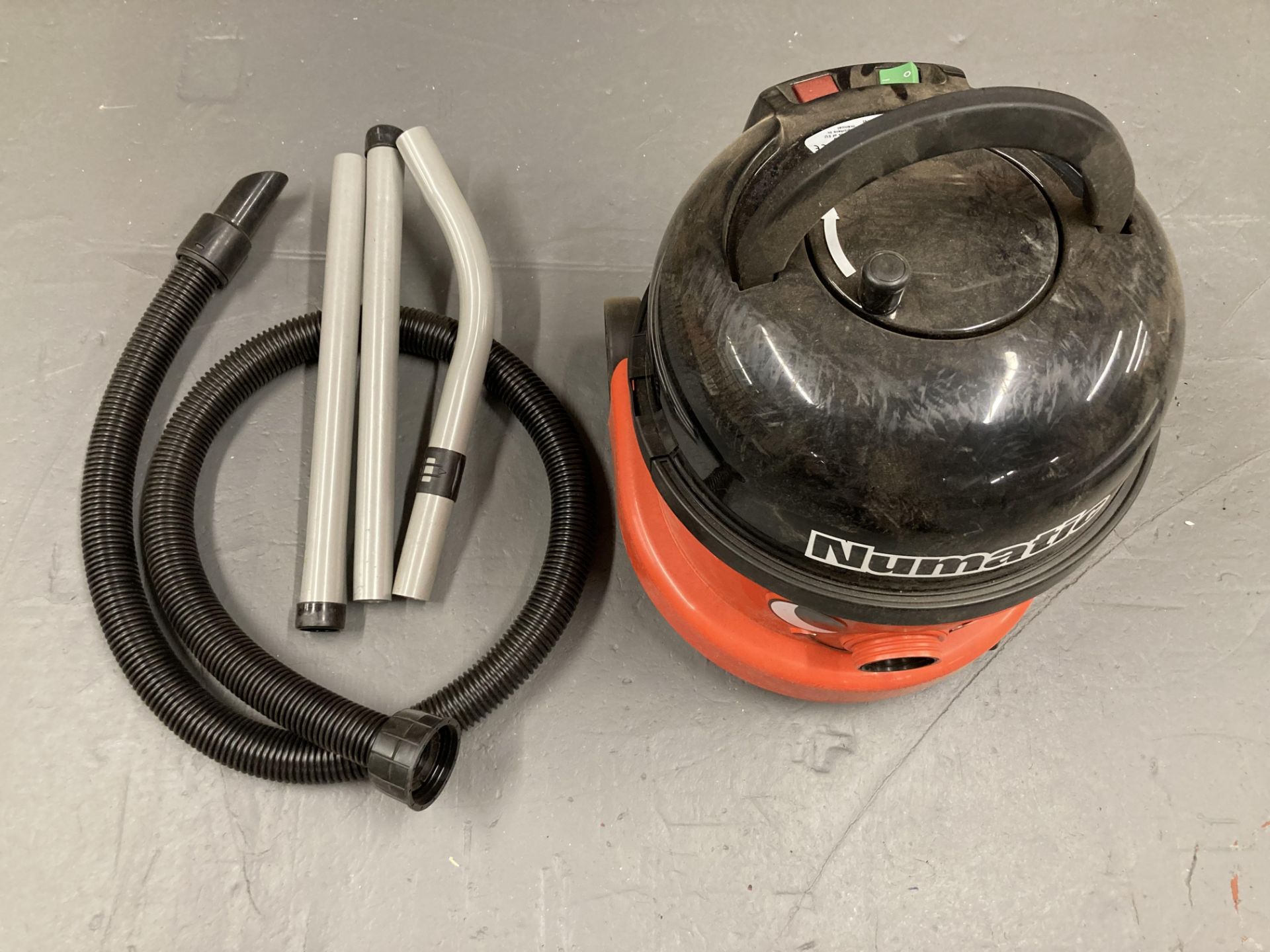 A Numatic vacuum with hose.