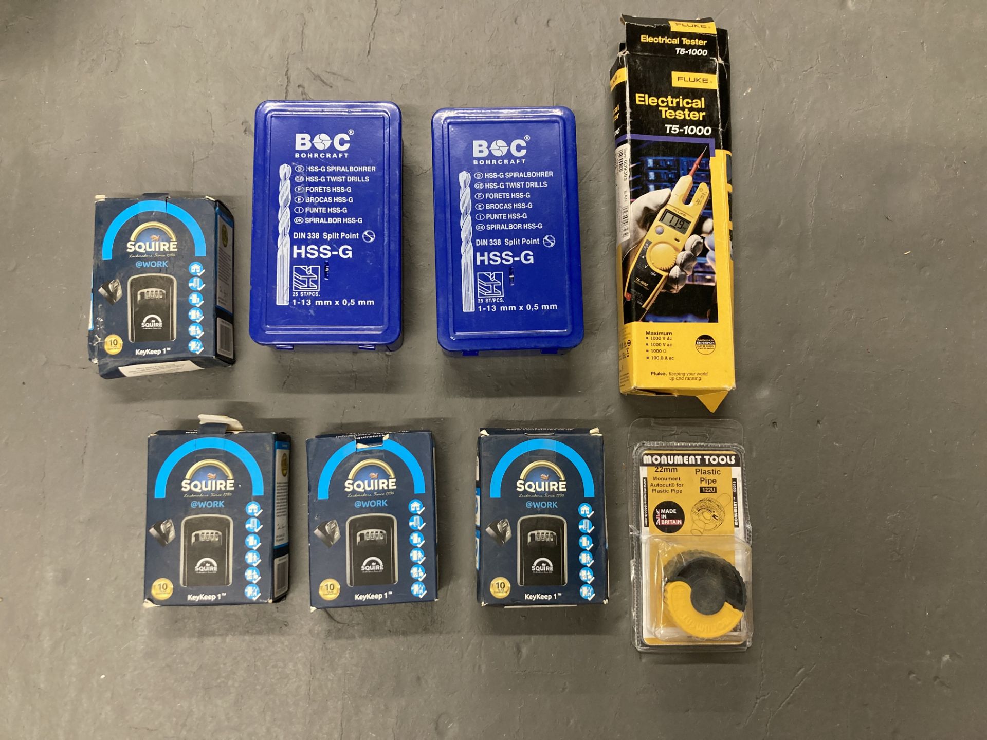Two sets of BOC drill bits, together with a Fluke electrical tester,