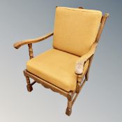 A continental carved oak ladder backed armchair in ochre fabric