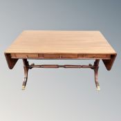 A reproduction mahogany drop end coffee table with brass lion paw feet