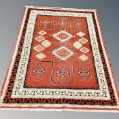 A contemporary Eastern style carpet on red ground,