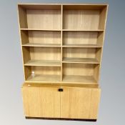 A Scandinavian oak effect bookcase fitted with cupboards,