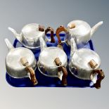 Five Picquot Ware teapots, all with wooden handles and hinged lids.