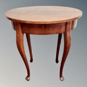 An oval occasional table on cabriole legs,