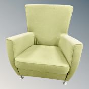 A 1970's armchair in green fabric on aluminium legs