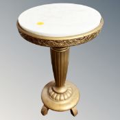 A gilt white marble topped pedestal table,