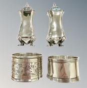 A pair of silver sifters and two silver napkin rings.