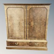 A burr walnut double door office cabinet with compartmental interior,