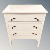 A cream three drawer chest,