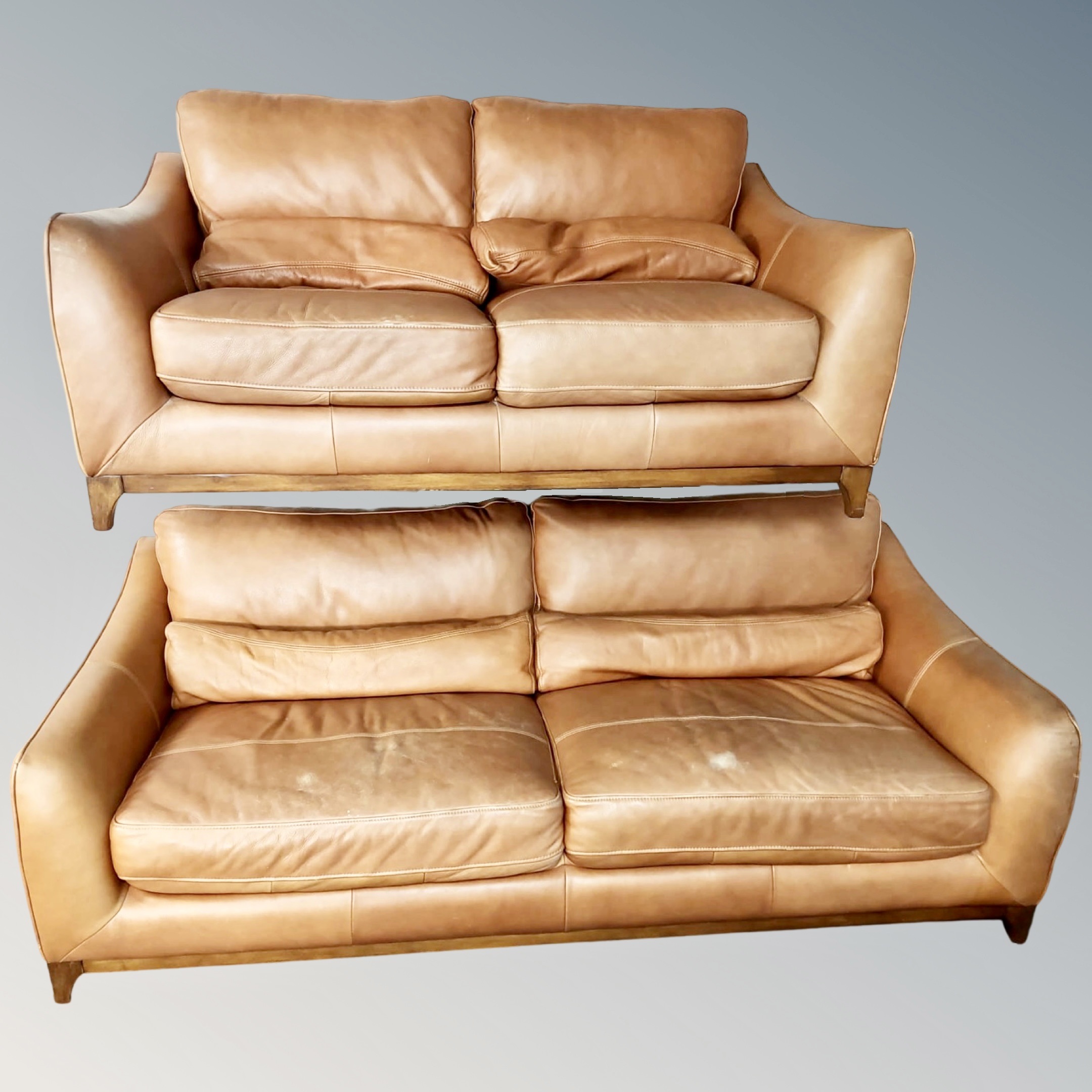 A tan leather three seater settee and matching two seater settee