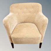 An armchair in beige dralon upholstery