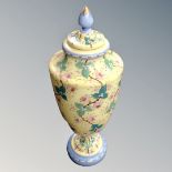 An over-painted opaque glass lidded urn,