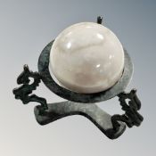 A 3" diameter polsihed marble globe on patinated stand