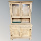 A carved oak bookcase fitted with cupboards and drawers,