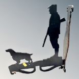 A painted metal wall bracket with form of a man and gun dog,