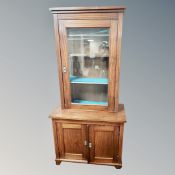 An inlaid mahogany double door cabinet with glazed bookcase above,