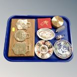 Three brass plaques mounted on an oak shield, two Imari pin dishes,