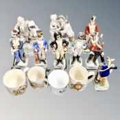 A tray of porcelain figures of soldiers in military uniform and commemorative mugs