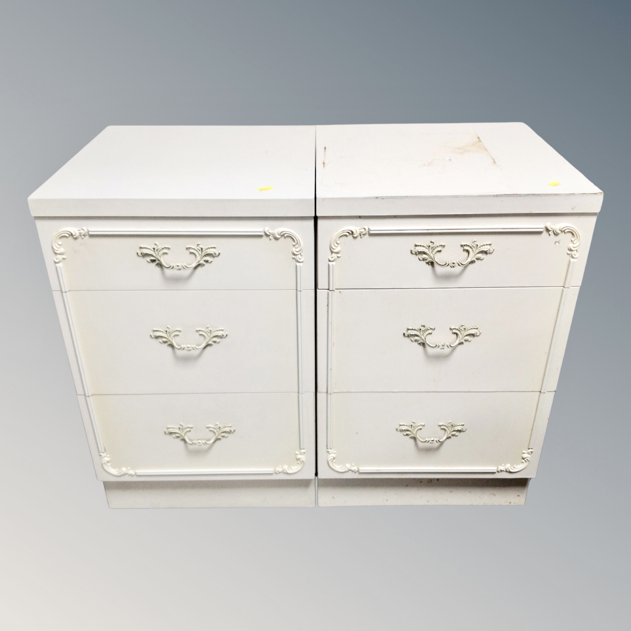 A pair of cream and gilt three drawer bedside chests
