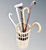 A wicker stick basket of walking sticks and umbrella