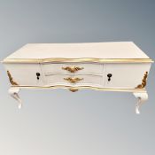 A continental cream and gilt low table fitted with drawers
