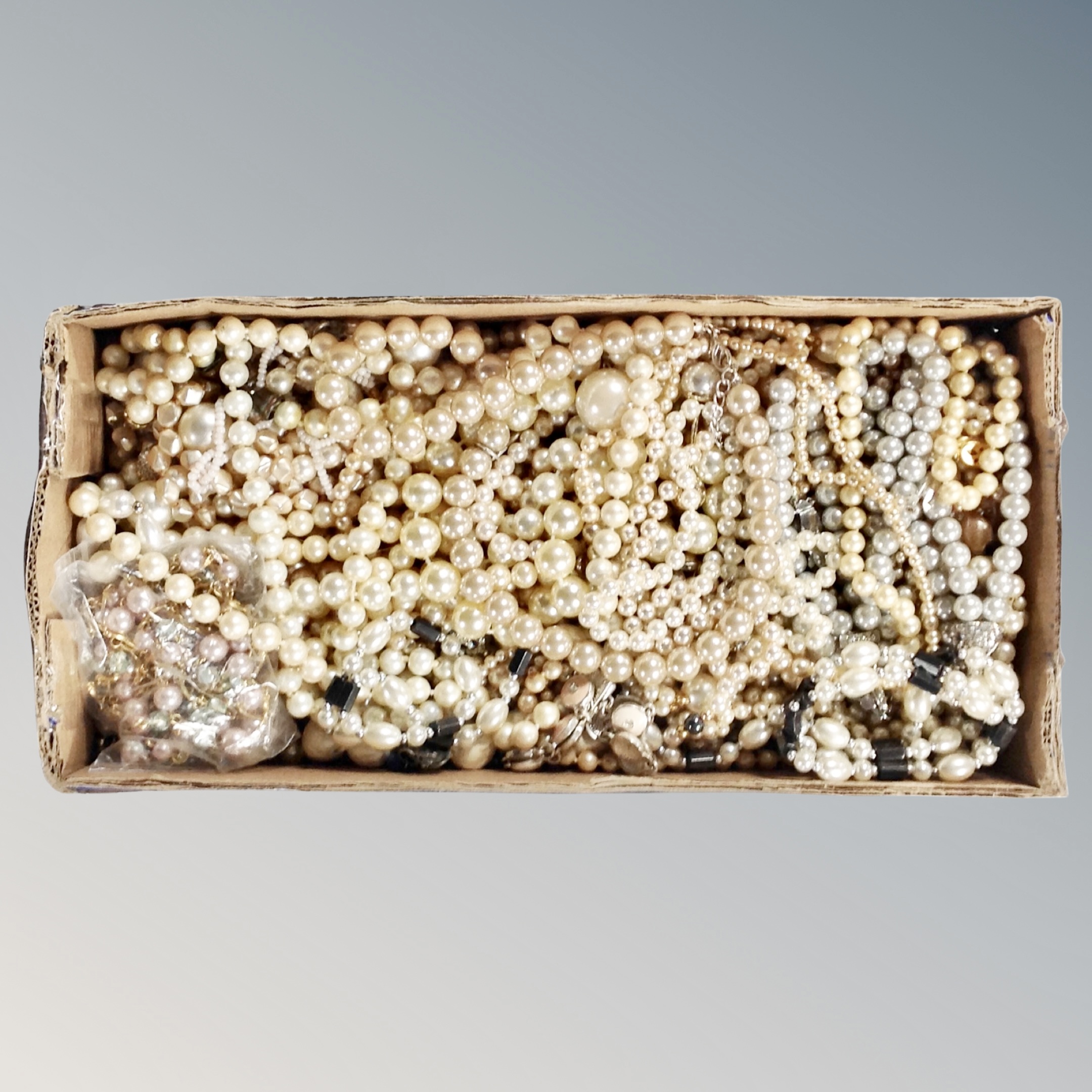 A box of faux pearls etc