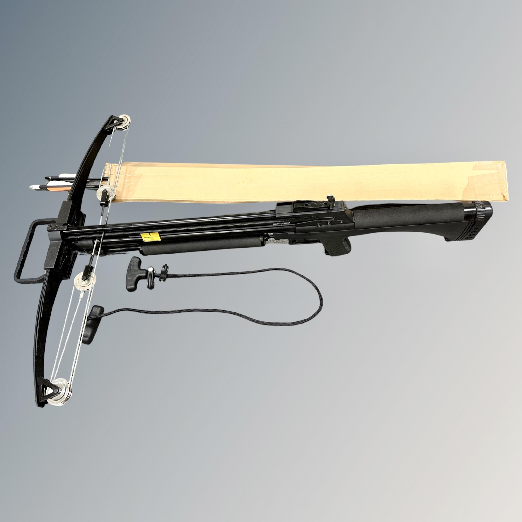 A crossbow with several bolts and drawing pull cord.