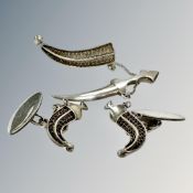 A pair of Middle-Eastern silver cuff links on the form of sheathed Jambiya knives,