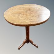 An oak tripod oval low table,