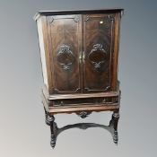 A Continental stained beech double door cabinet on stand,