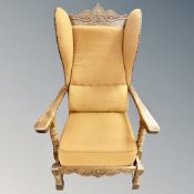 A continental carved oak wing backed armchair