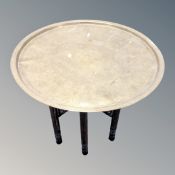 A Middle Eastern brass topped occasional table on folding stand