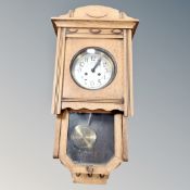An early 20th century oak eight day wall clock with silvered dial,