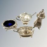 Three silver condiment pots, two salt spoons and a silver pepper pot,
