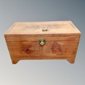 A carved camphor wood blanket chest with metal lock