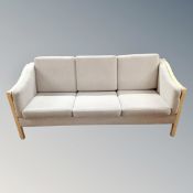 A Scandinavian wood framed three seater settee and matching two seater settee with grey fabric