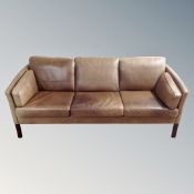 A Scandinavian brown leather three seater settee