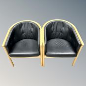 A pair of beech tub chairs in black leather