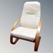 A Scandinavian beech framed armchair with cream leather cushion