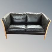 A Stouby wood framed black leather two seater settee
