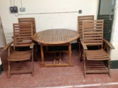 A circular teak extending dining table fitted internal leaf,