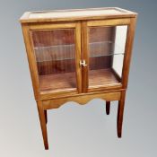 A double door curio display cabinet on stand