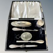 A silver backed manicure part-set in fitted case and a silver mounted double sided locket